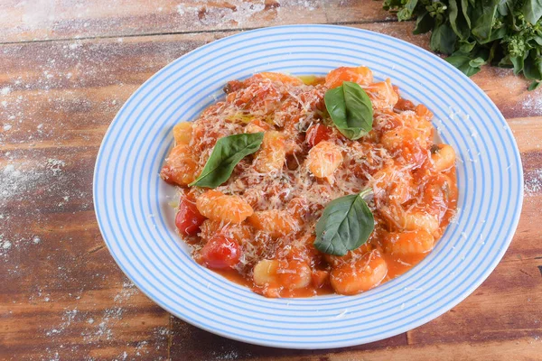 italian pasta in red sauce with parmesan cheese, tomato, basil, herbs, delicious food from Italian and French cuisine