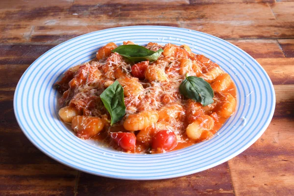 italian pasta in red sauce with parmesan cheese, tomato, basil, herbs, delicious food from Italian and French cuisine