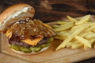 Sığır burger salatalı sandviç soğan peyniri ve domuz pastırmalı fast food.