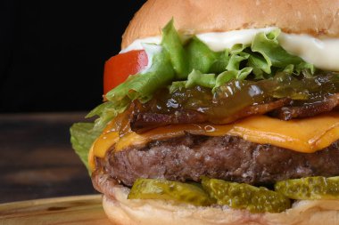 Sığır burger salatalı sandviç soğan peyniri ve domuz pastırmalı fast food.