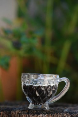 Kırsal ahşap tabanlı, bulanık arka planı olan bir kahve fincanı.