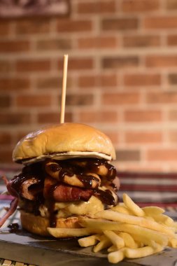 Sığır burger salatalı sandviç soğan peyniri ve domuz pastırmalı fast food.