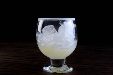 Siyah arkaplanda tuz bulunan limon suyu.