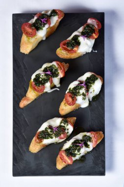 Peynirli ve domatesli bruschetta ekmeği.
