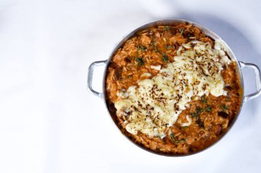 Sosisli risotto, İtalyan pilavı İtalyan sosisi ve soğan biberiyle servis edilmiş, üzerine parmesan peyniri soslu baharatlı domates sosu katılmış...