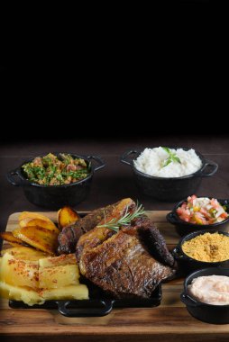 Izgara Chuck Eye Roll bifteği kıyma tahtasında kızartılmış. Fasulye salatası ve barbekü. en üstteki görünüm