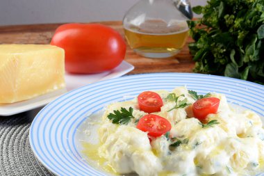 rondelli cannelloni delicious gnocchi pasta in white sauce with parmesan cheese, tomatoes, basil, herbs, healthy food of Italian and French cuisine.