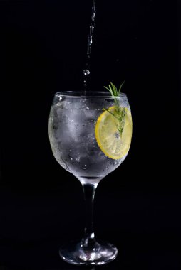 alcoholic iced drink of gin and tonic vodka soda citrus fruit juice lemonade with cinnamon isolated on black background