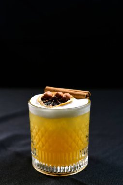 citrus fruit alcoholic iced drink fruit juice with cinnamon isolated on black background