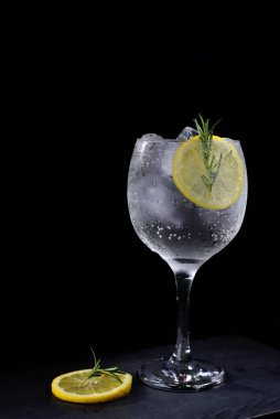 alcoholic iced drink of gin and tonic vodka soda citrus fruit juice lemonade with cinnamon isolated on black background