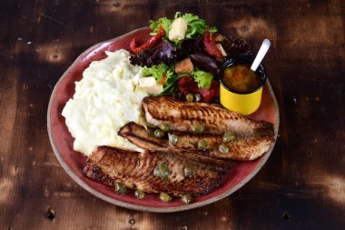 fried fish fillet with boiled mashed potatoes and salads