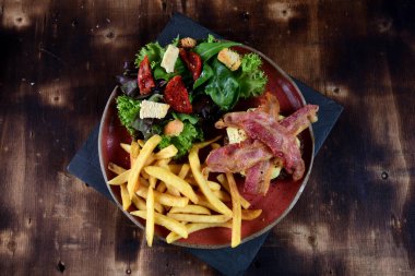 hamburger with fries salad and bacon with cheese