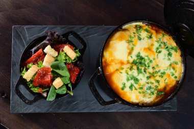 rice with meat sausage bacon and melted cheese served with salad and bread toast