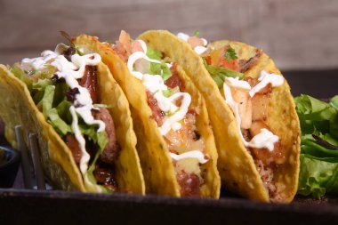 Meksika yemeği takoları, kızarmış tavuk, yeşillikler, mango, avokado, biber, kırmızı lahana ve tortilla karışımı