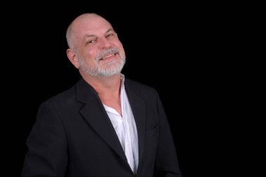 Siyah arkaplana karşı poz veren orta yaşlı yakışıklı bir adam. Kendine güvenen iş adamı