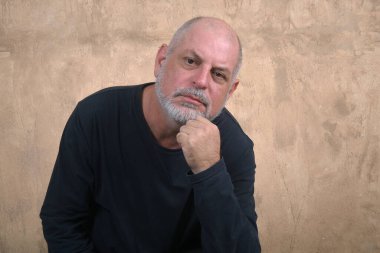 Mutlu, yakışıklı, yaşlı, sıradan bir adam evde, gülümsüyor. Orta yaşlı bir yetişkin portresi, daha yaşlı, mutlu, gülümseyen, olgun, gri saçlı bir adam.