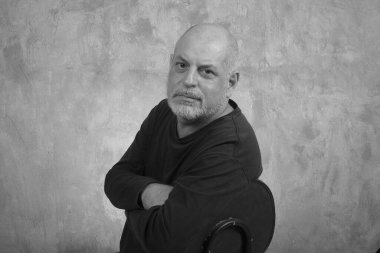 Mutlu, yakışıklı, yaşlı, sıradan bir adam evde, gülümsüyor. Orta yaşlı bir yetişkin portresi, daha yaşlı, mutlu, gülümseyen, olgun, gri saçlı bir adam.