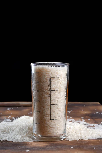 木のテーブルの上の白い米の天然の長い米の粒テクスチャの背景 — ストック写真