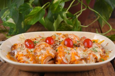 mozzarella peynirli kızarmış tavuk ve vişneli domates ve karamelli soğan ahşap masada lezzetli yemekler.