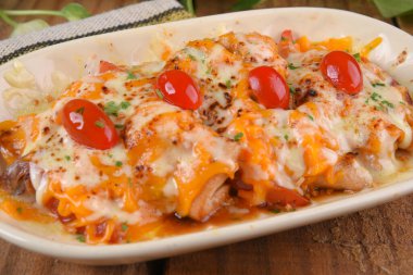 mozzarella peynirli kızarmış tavuk ve vişneli domates ve karamelli soğan ahşap masada lezzetli yemekler.