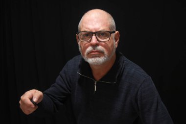 Erkek portresi beyaz sakallı. Düşünceli, gözlüklü yetişkin bir adam.