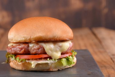 Hamburger sandviç ve erimiş peynirli marul, domates mayonezi ve ekmek lezzetli fast food geleneksel atıştırmalıklar.