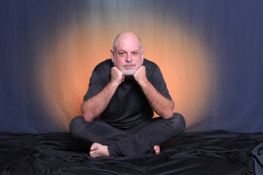 Kel, yetişkin bir adam yerde oturuyor, rahatlıyor, meditasyon yapıyor, yoga yapıyor..