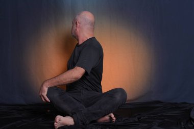 Kel, yetişkin bir adam yerde oturuyor, rahatlıyor, meditasyon yapıyor, yoga yapıyor..