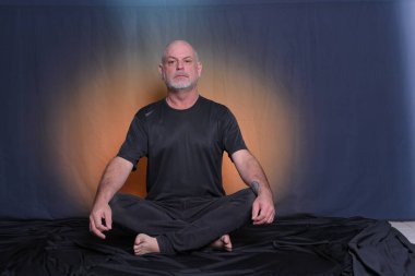 Kel, yetişkin bir adam yerde oturuyor, rahatlıyor, meditasyon yapıyor, yoga yapıyor..