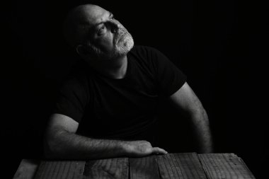 Şarap suratlı bir adam oturuyor. Siyah beyaz fotoğraf ve silüet yetişkin içkisi.