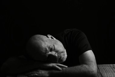 Şarap suratlı bir adam oturuyor. Siyah beyaz fotoğraf ve silüet yetişkin içkisi.