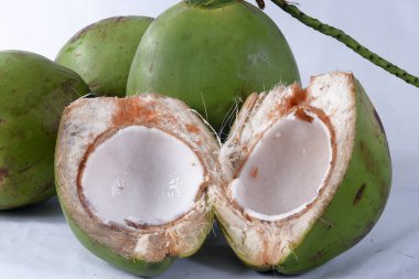 Bahia 'dan yeşil hindistan cevizi, doğal hindistan cevizi suyu, tropikal meyve, yarım meyve ve beyaz arka planda lezzetli organik saudadel bitkisi.