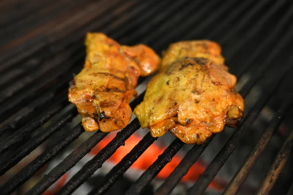 chicken with greens and vegetables roasting on a charcoal barbecue lit wood with fire for roasting chicken on the grill taste image