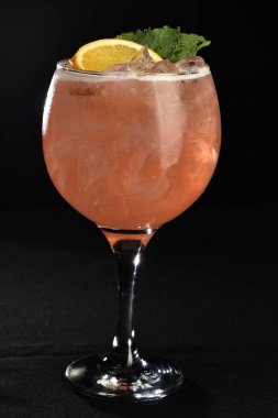 Meyveli ferahlatıcı alkollü içecek, soğuk votka ve cin, cam bardakta servis edilen limon kabuğu.