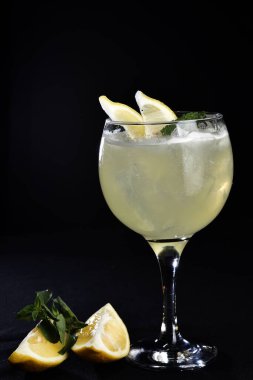 Meyveli ferahlatıcı alkollü içecek, soğuk votka ve cin, cam bardakta servis edilen limon kabuğu.