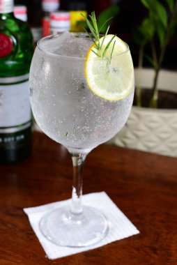 Meyveli ferahlatıcı alkollü içecek, soğuk votka ve cin, cam bardakta servis edilen limon kabuğu.