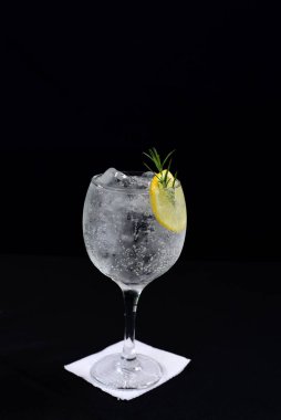 Meyveli ferahlatıcı alkollü içecek, soğuk votka ve cin, cam bardakta servis edilen limon kabuğu.