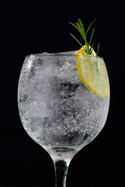 Meyveli ferahlatıcı alkollü içecek, soğuk votka ve cin, cam bardakta servis edilen limon kabuğu.