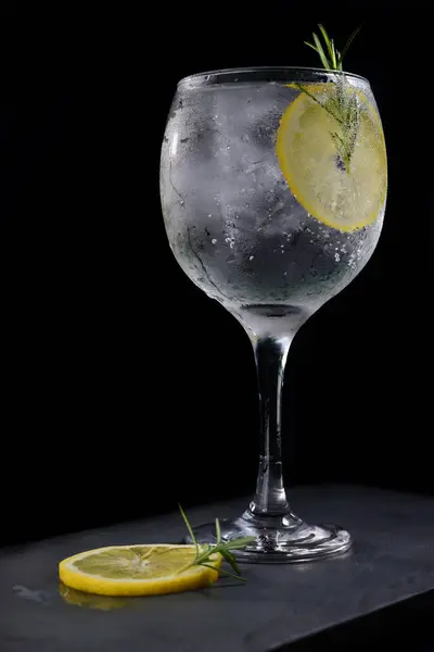 refreshing alcoholic drink with fruits, chilled vodka and gin, lemon peel served in glass tumbler