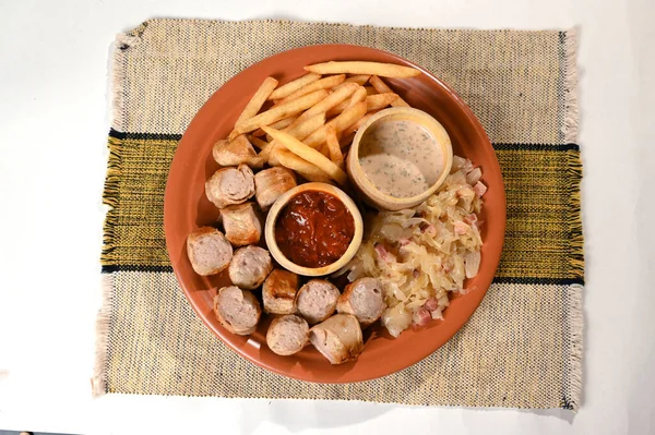 plate for food French fries sausage white sausage and sauerkraut herb sauce and ketchup typical German food taste