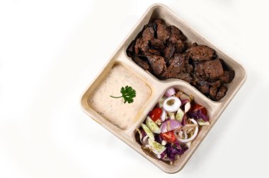 Beyaz arka planda izole edilmiş biyolojik çözünürlüklü paket içinde salata ve bitki soslu kızarmış et.