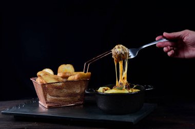 Sosla kaplı köfteler, erimiş peynir ve salata.