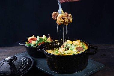 Sosla kaplı köfteler, erimiş peynir ve salata.