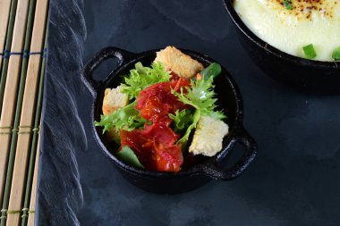 Sosla kaplı köfteler, erimiş peynir ve salata.