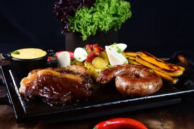 Domuz pastırmalı biftek, kızarmış patates ve salatalı salata.