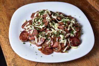 Kızarmış pepperoni, soğan ve peynirli fast food.