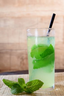 Böğürtlenli, buzlu ve cinle ferahlatıcı alkollü içecek, cam bardakta servis edilen limon kabuğu arka planda bulanık iamge.