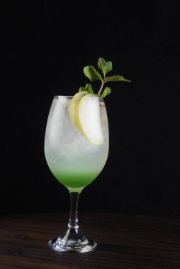 Böğürtlenli, buzlu ve cinle ferahlatıcı alkollü içecek, cam bardakta servis edilen limon kabuğu arka planda bulanık iamge.