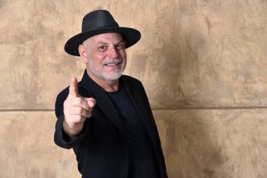 Kel yetişkin adam beyaz sakallı yüz ifadesi siyah elbiseli ve şapkalı erkek model beyefendi.