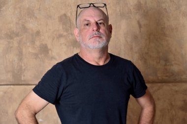 Yetişkin, beyaz sakallı, siyah giysili bir erkek model.